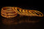 A stack of ornate gold bangles on a dark surface.