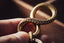 a person holding a gold ring in their hand