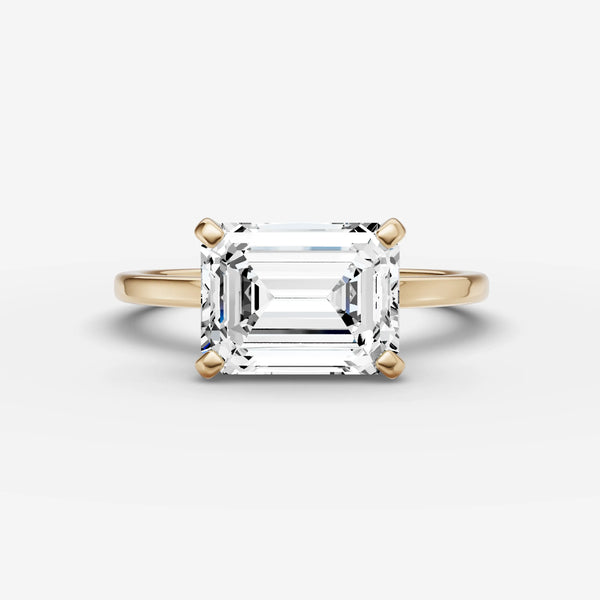 East-west solitaire engagement ring setting with emerald-cut stone in yellow gold, front view