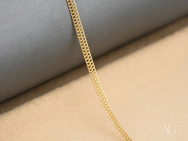 Close-up detail of 18K gold chain links showing double curb pattern
