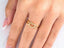 Elegant 18k yellow gold heart ring with small clear stones on finger