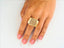 Elegant 18k yellow gold ring with textured rectangular top and diamond cut pattern