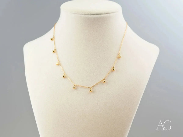 Elegant 18K gold beaded necklace with delicate spherical charms