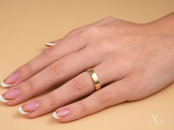 Womans hand with 18k yellow gold Essence Linea 4mm ring