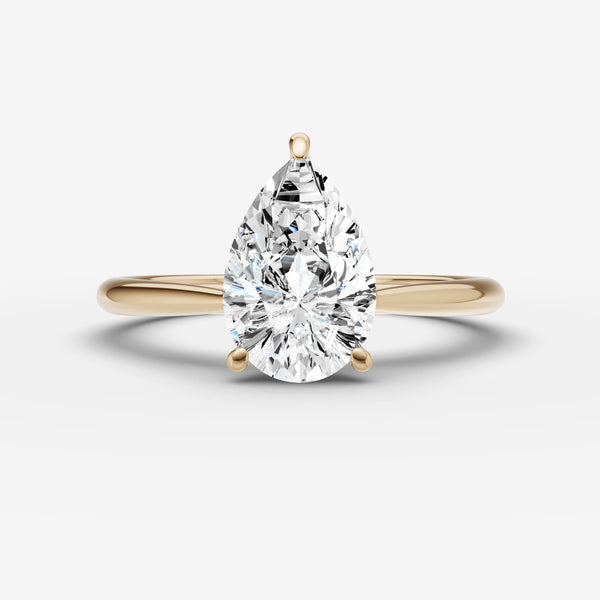 Pear-cut cathedral engagement ring setting in yellow gold, front view with three-prong setting