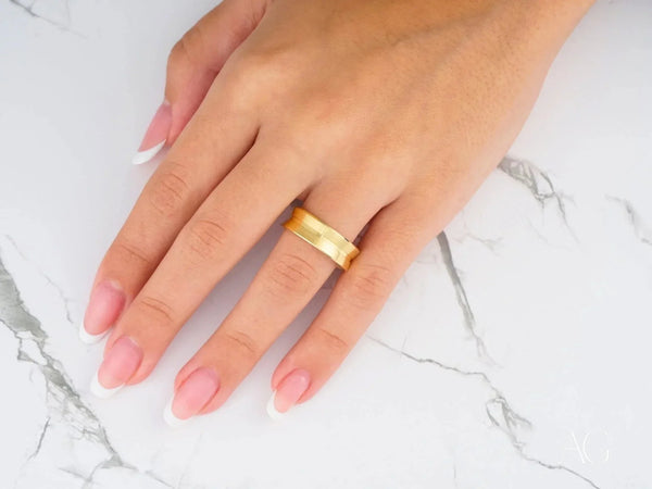 Womans hand with Golden Horizon comfort fit raised central art gold jewelry band