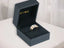 Gold ring with white and blue stones in black velvet box, showcasing Golden Spectrum elegance meets versatility