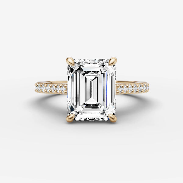 Front view of emerald-cut cathedral engagement ring setting with pave diamond band in yellow gold