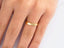 Plain 18k yellow gold wedding band on finger from Timeless 18k yellow gold jewelry collection