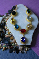 Vibrant multi-colored 18k gold birthstone necklace with blue pendant