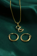 Gold hoop earrings with greek key pattern and matching 18k gold chain necklace showcasing fine gold jewelry elegance