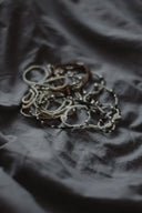 Bracelets and jewelry lie scattered on fabric.