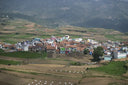 Village nestled in the mountains with surrounding fields.