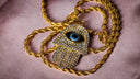 a gold necklace with an evil eye on it