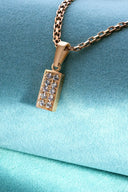 A rose gold rectangular pendant with cubic zirconia stones on a matching chain showcasing 18k gold fine jewelry