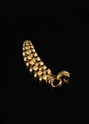 a close up of a gold bracelet on a black background