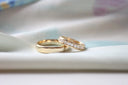 A pair of gold wedding bands with one featuring diamonds along the inner edge from an everett jewelry store.