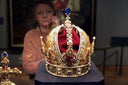 Golden crown jewels with pearls, rubies and blue gemstone peak