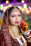 Bride in traditional indian wedding attire and jewelry.