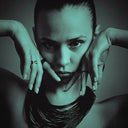 Woman with hands framing her face and wearing necklace