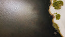 Aerial view of dark water shoreline near art gold jewelry fine 18k gold chain masters