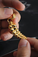 a person holding a gold bracelet in their hand