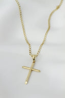 A gold cross necklace on a mannequin