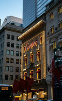 The illuminated Cartier storefront features gold lighting and red awnings highlighting fine jewelry and art gold designs.