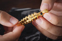 Gold jewelry featuring a golden textured chain with polished rounded links and a detailed clasp in ethical art gold jewelry design