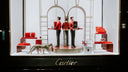 Red cartier handbag displayed on a pedestal in an elegant window highlighting fine jewelry and art gold jewelry trends