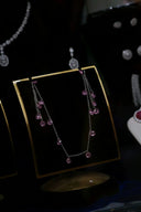 A delicate silver chain necklace with cascading pink gemstones featured in birthstone jewelry for personalized gifts.