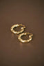 a pair of gold hoop earrings on a brown surface