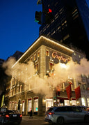 The illuminated Cartier building with gold lights and red flags highlights fine jewelry and art gold jewelry excellence.