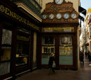 The ornate wooden facade of the Longines watch shop features multiple clocks and vintage signage highlighting fine jewelry.