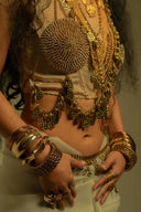 Woman adorned with ornate gold jewelry and costume.