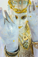 Cleopatra in 18k gold jewelry with shimmering glitter makeup and ornate headpiece