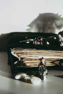 A vintage-style black leather-bound journal with aged pages illustrating cultural insights on engagement rings and wedding bands from everett jewelry store.