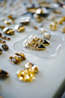 Custom gold jewelry featuring fine gold earrings with black triangular accents and pearl-like beads in art gold design