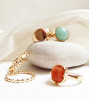 Gold-toned 18k gold rings with polished turquoise and coral gemstones showcasing handmade gold jewelry design