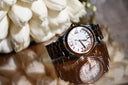 A sleek rose gold Chopard watch with white dial, roman numerals, and 18k gold jewelry embellishments.