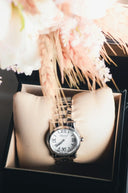 A sleek silver toned chopard watch with white dial and roman numerals in a presentation box at everett jewelry store