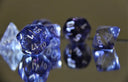 Translucent blue polyhedral die amid famous cursed gems mystery