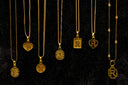 Several gold necklaces with initial pendants displayed.