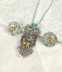 three pieces of jewelry sitting on top of a bed