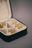 Gold-toned geometric hoop earrings in black velvet box showcasing custom gold jewelry for engagement ring art.
