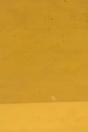 a man riding a skateboard down a street next to a yellow wall