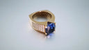 Gold ring with a deep blue gemstone and diamonds in 18k gold showcasing fine jewelry for personalized gifts.