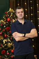 a man standing in front of a christmas tree