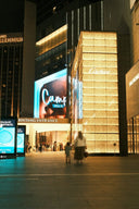 Illuminated Cartier storefront with luxury jewelry facade and golden lighting