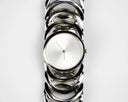 Silver-toned watch with minimalist design, interlocking circular links, and white dial in art gold jewelry context